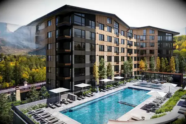 Luxury apartments with a large outdoor pool and mountain views, featuring a Travel & Lanetrek award badge for 2025
