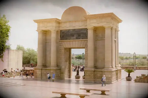 Monumental stone archway structure with people walking nearby