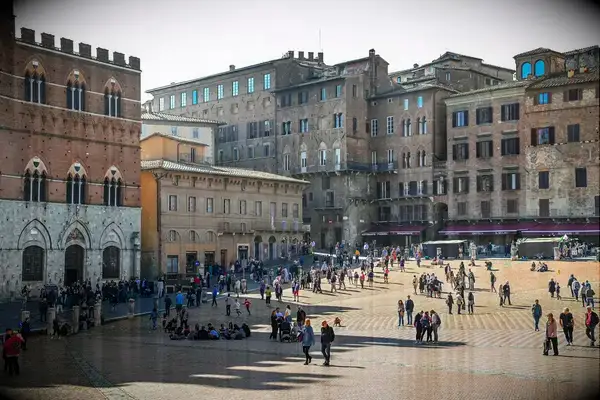 A public square surrounded by historic buildings with people walking and gathering