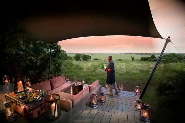 Outdoor lounge area with a canopy featuring a person serving drinks in a scenic natural setting for Travel Lanetrek Worlds Best Awards 2025