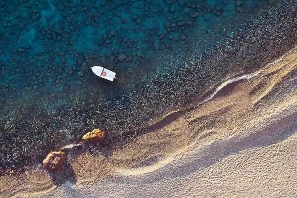 Aerial view of a small boat off the coast of Milos, Greece
