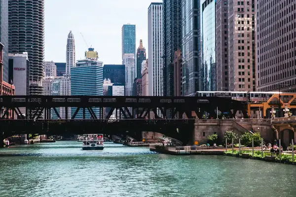 Downtown Chicago skyline with a bridge over a river and a boat passing underneath